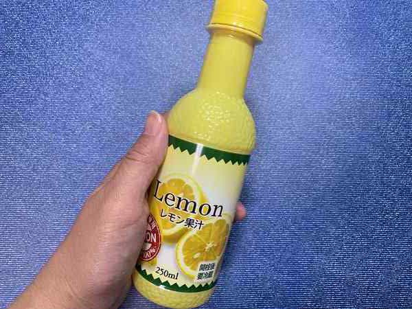 業務スーパーレモン果汁のボトルを手に持っているところ