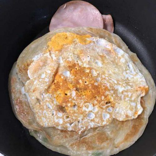 フライパンで焼いているハム・卵・業務スーパーの葱抓餅