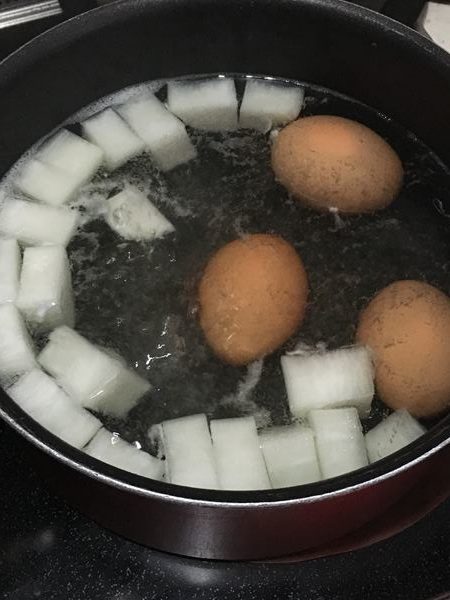 １つの鍋で茹でている大根と卵