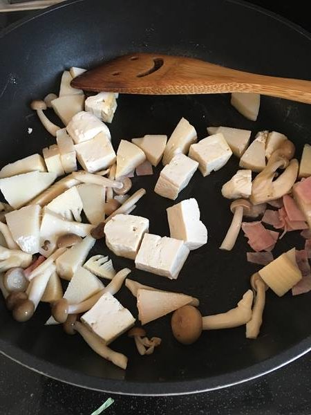 フライパンでベーコン・たけのこ・豆腐・しめじを炒める様子