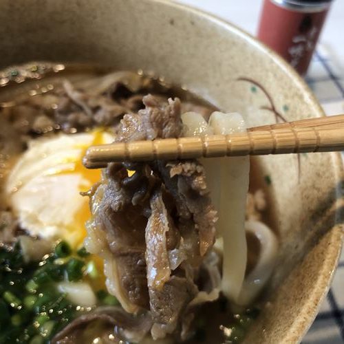 箸で持ち上げた肉うどん