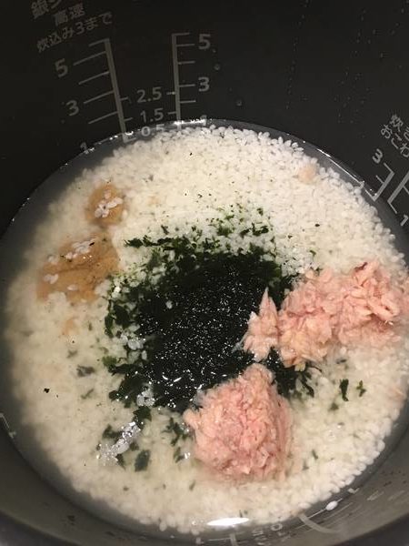お米と即席みそ汁が入った炊飯器に加えた乾燥わかめとツナ缶