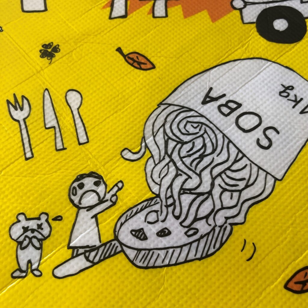 業務スーパーの黄色のエコバッグに描かれてる巨大焼きそばを作ってるイラスト