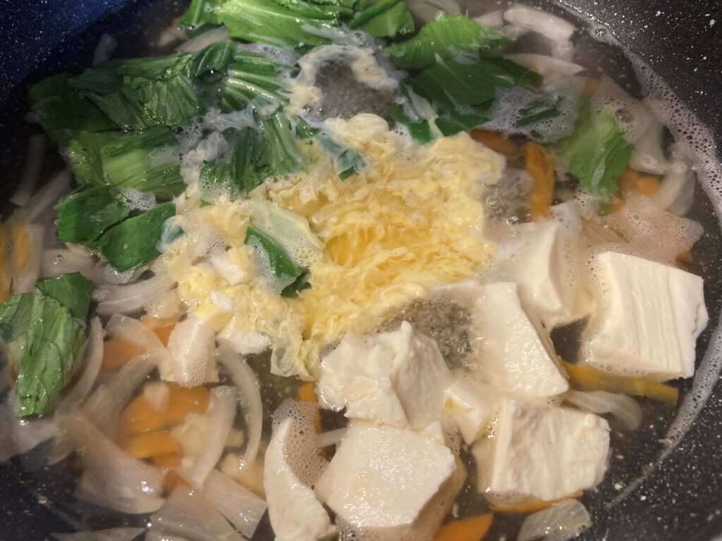 豆腐をちぎり入れて茹でて沸騰したら溶き卵を入れる