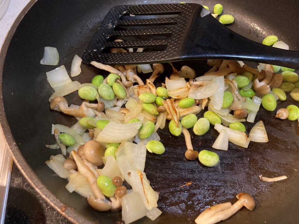 フライパンで玉ねぎしめじ、むき枝豆を炒める