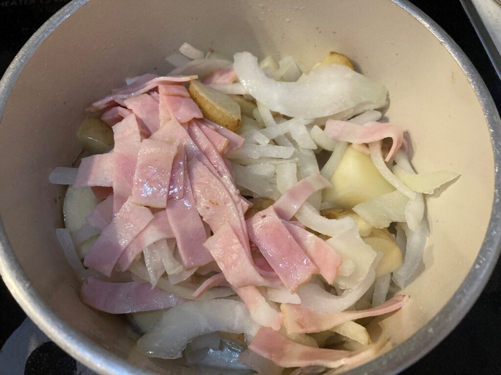 鍋でじゃがいもを炒めて透き通ってきたら凍ったままのスライスたまねぎとベーコンを入れて炒める