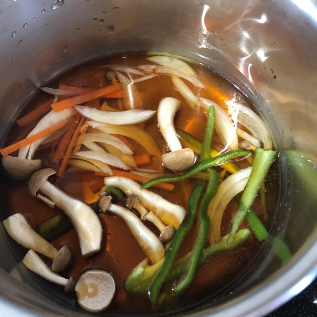 鍋に調味料と野菜を入れる