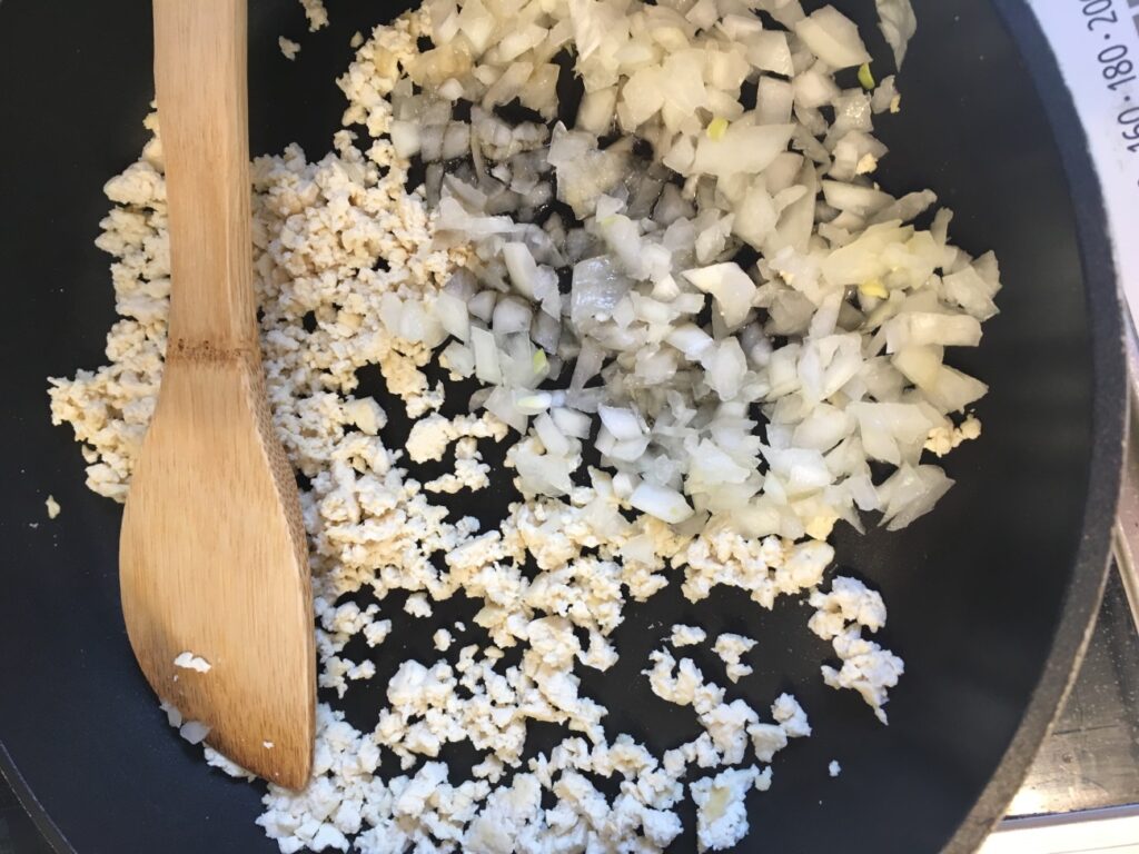 豆腐がそぼろ状になったら玉ねぎを入れて炒める