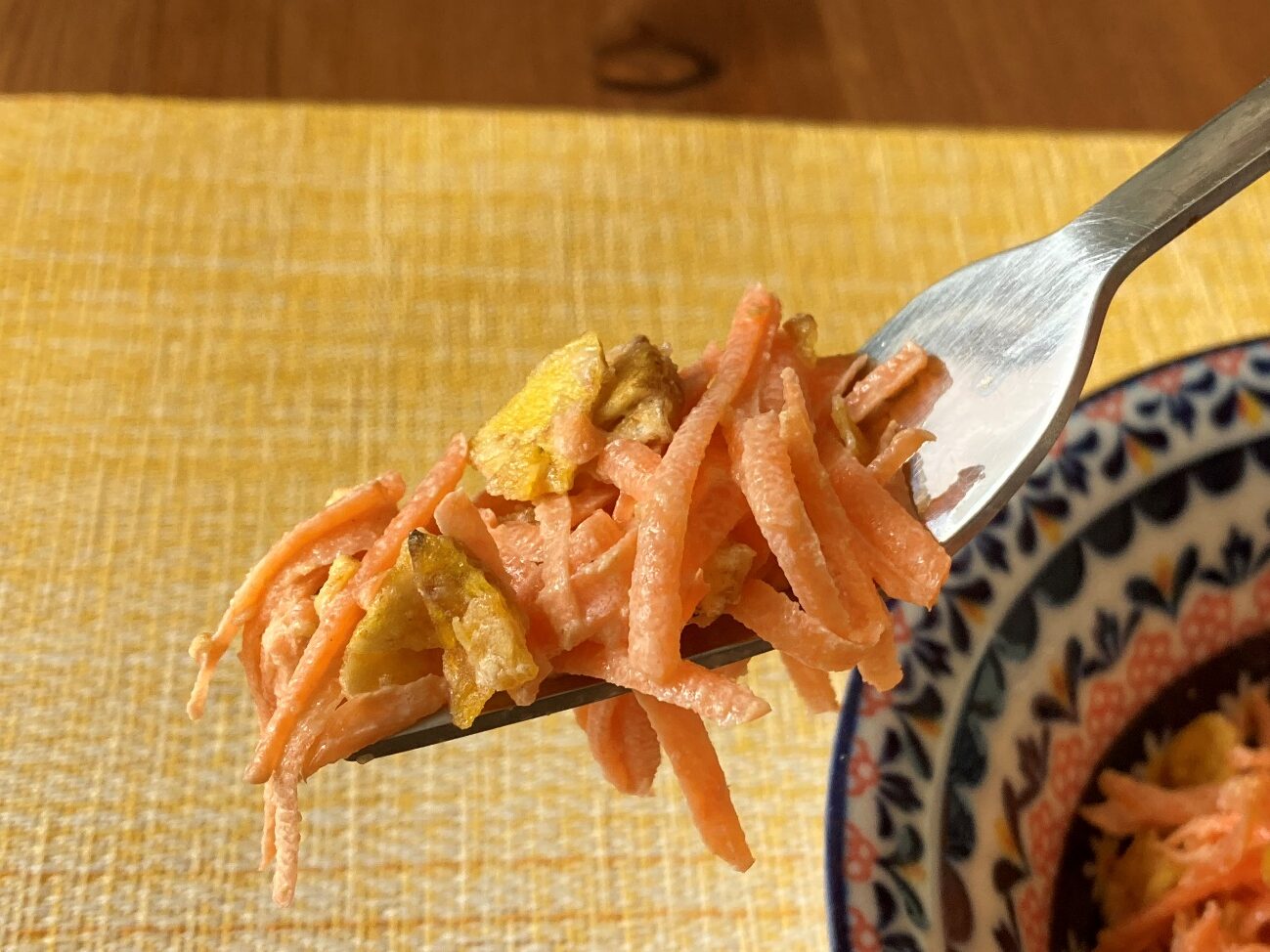 フォークですくい上げたプランテンチップスハラペーニョ味を使ったピリ辛人参サラダ