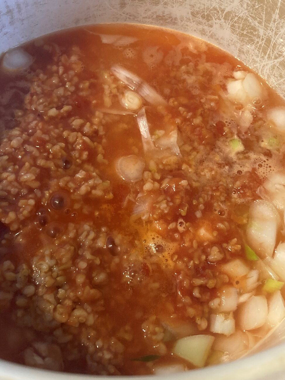 鍋に入れたねぎ・玄米トマトリゾット・鶏がらスープの素を煮込んでいるところ
