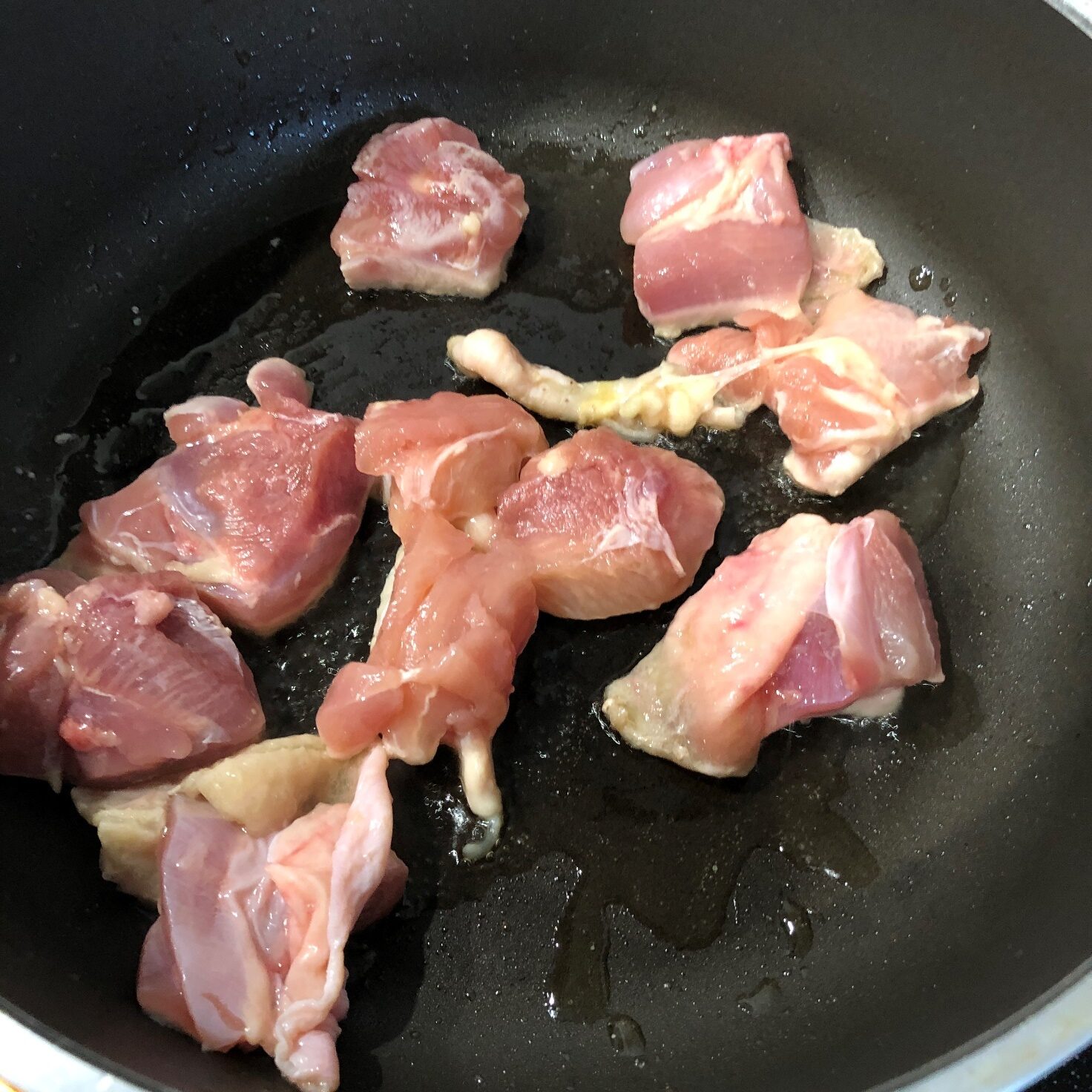 一口大に切った鶏もも肉をごま油で炒める