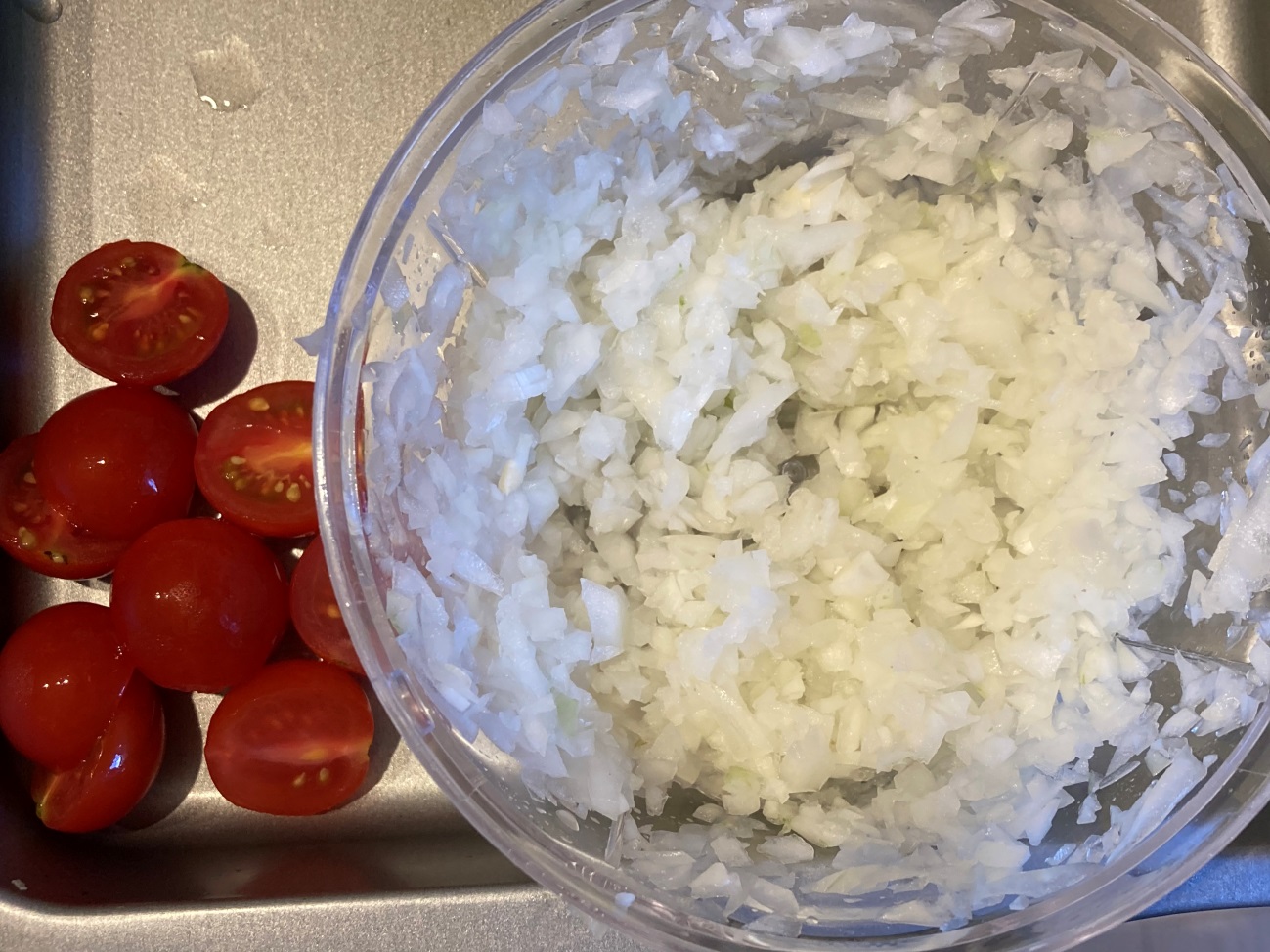 ミニトマトを半分、玉ねぎをみじん切りにする
