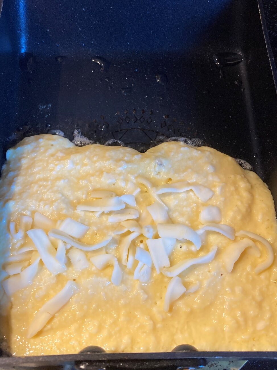 卵焼き用フライパンに豆腐生地を半分流して、チーズをのせる