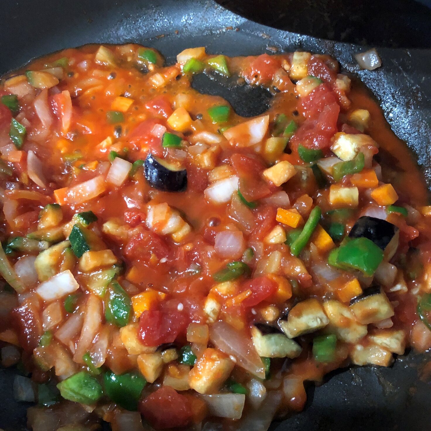 炒めた野菜にトマト缶を加えて煮る