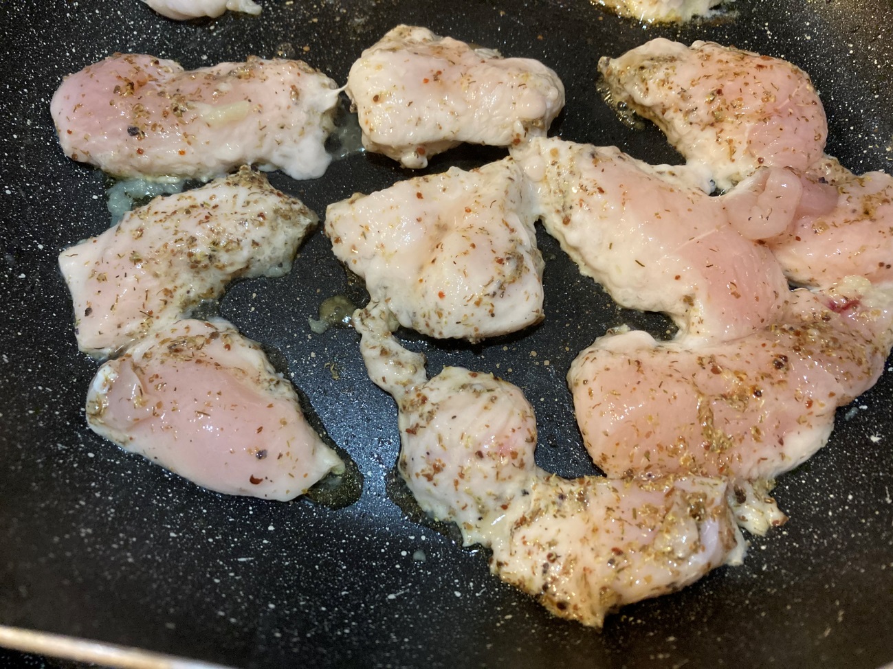 オリーブオイルとにんにくチューブを入れたフライパンで鶏胸肉を焼く