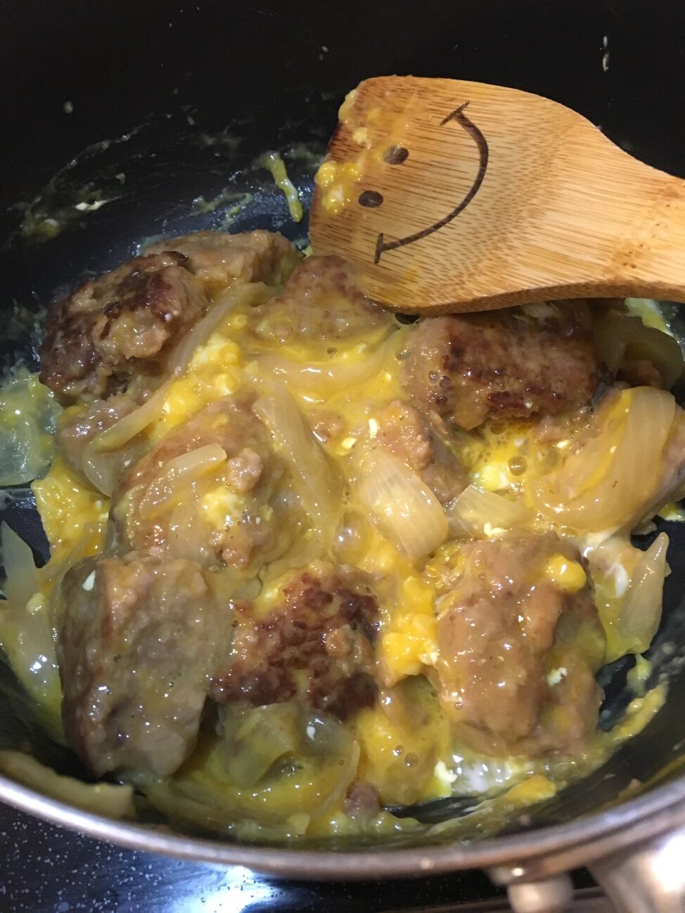あらびきハンバーグが入った鍋に卵液を流し入れる