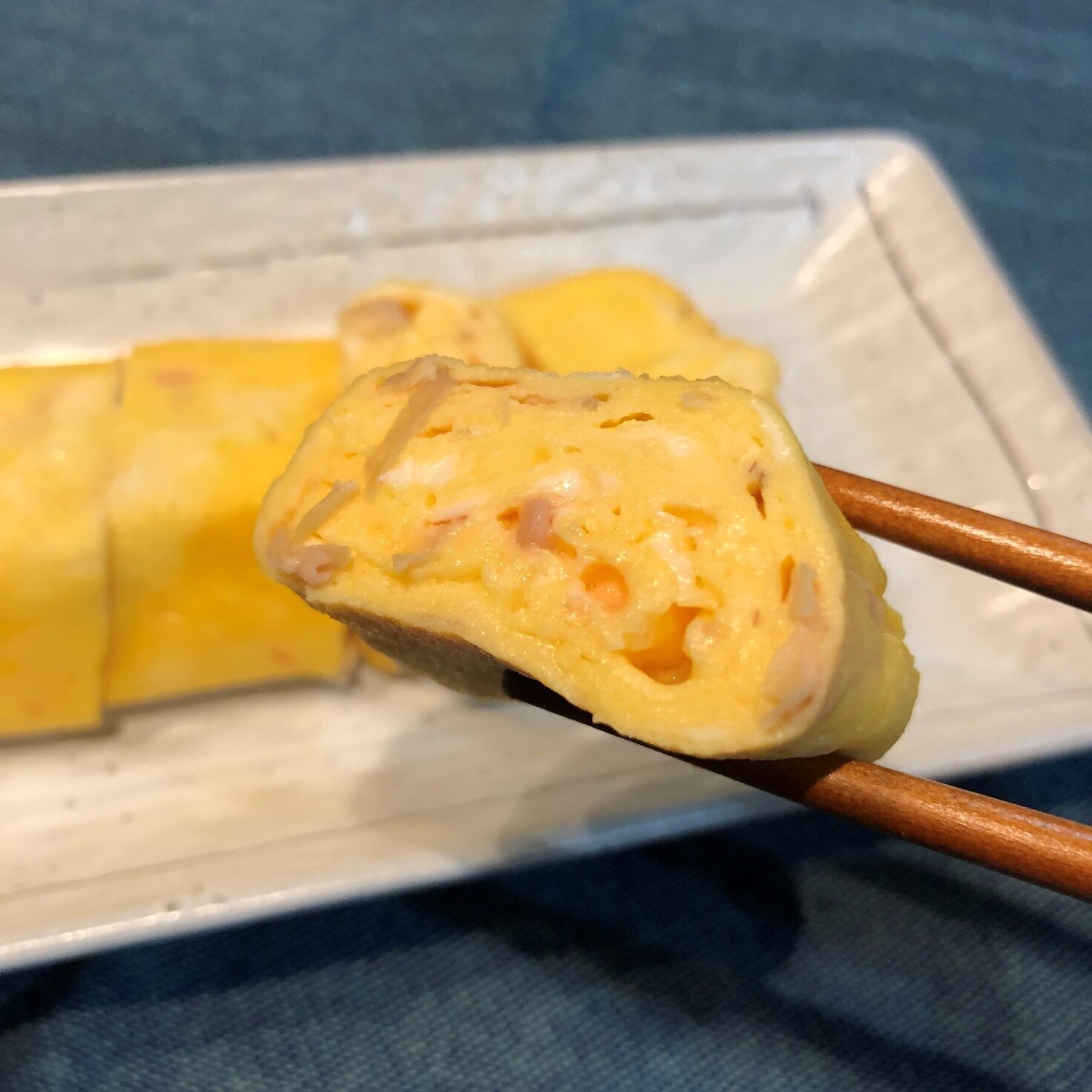 箸で持ち上げた業務スーパーの甘酢平切生姜入り玉子焼きのアップ