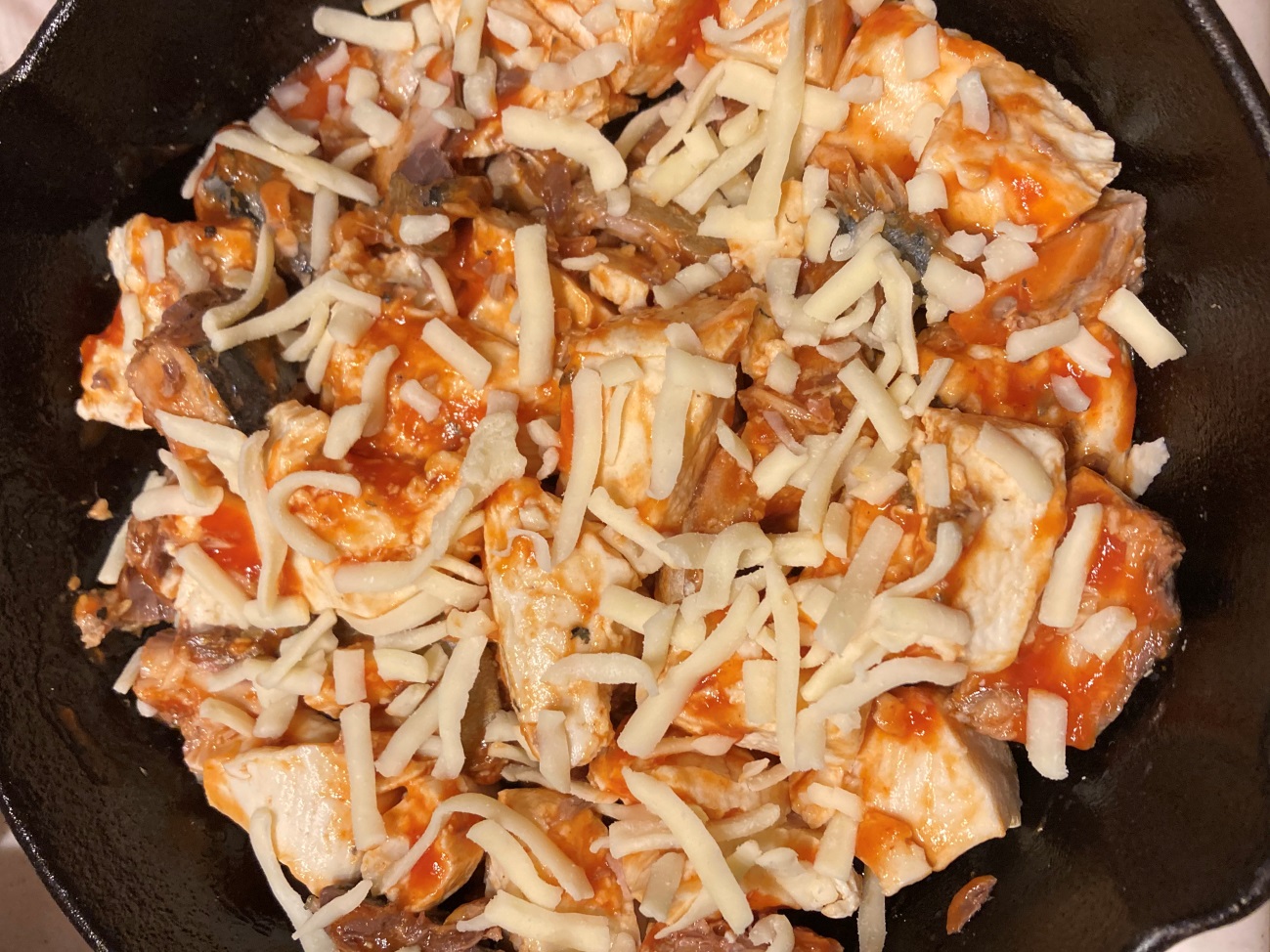 なめらかトマトソースを和えた豆腐とサバの水煮にピザ用チーズを散らす