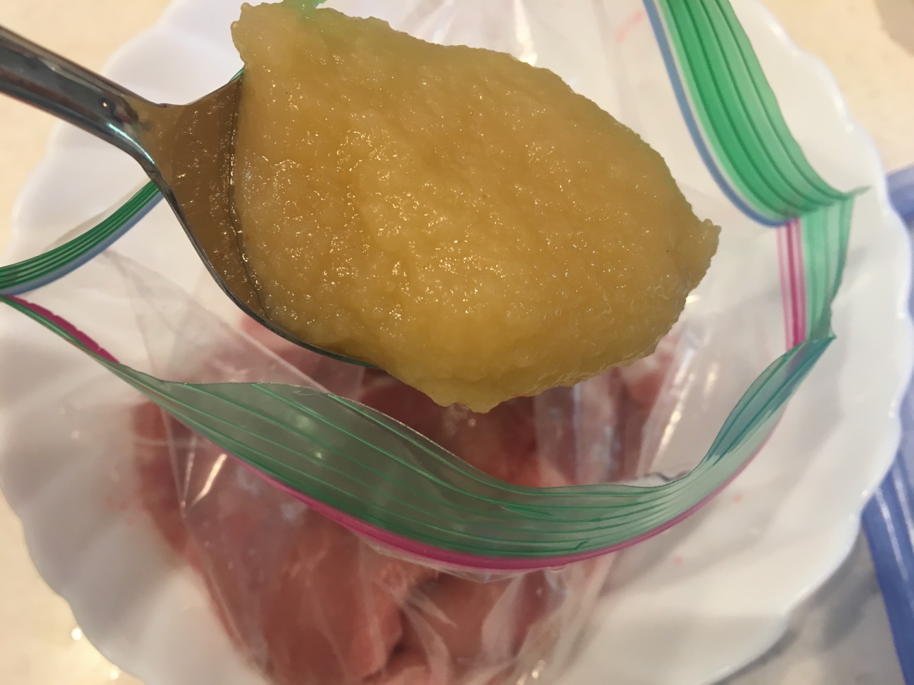 豚カルビ肉・業務スーパーのアップルソース・生姜を密閉袋に入れる