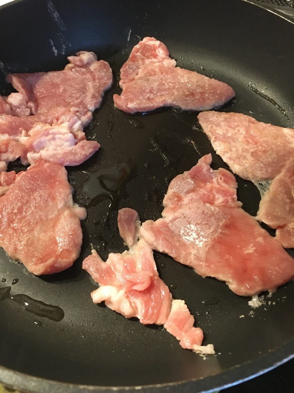 フライパンで薄力粉をつけた豚肉を両面焼く