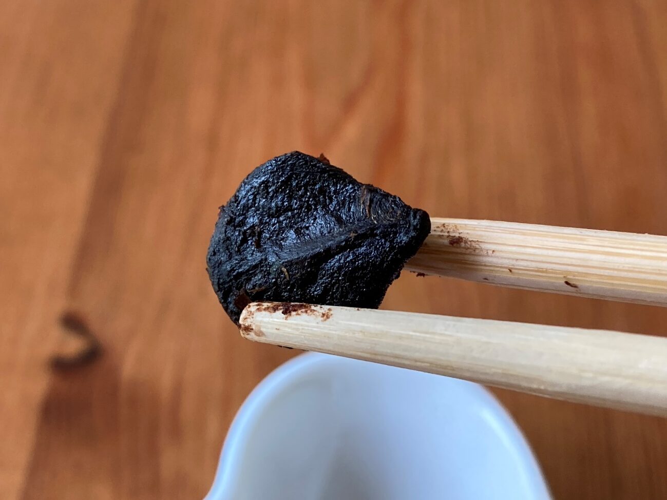 箸で持ち上げた業務スーパーの「小粒で甘みのある黒にんにく」