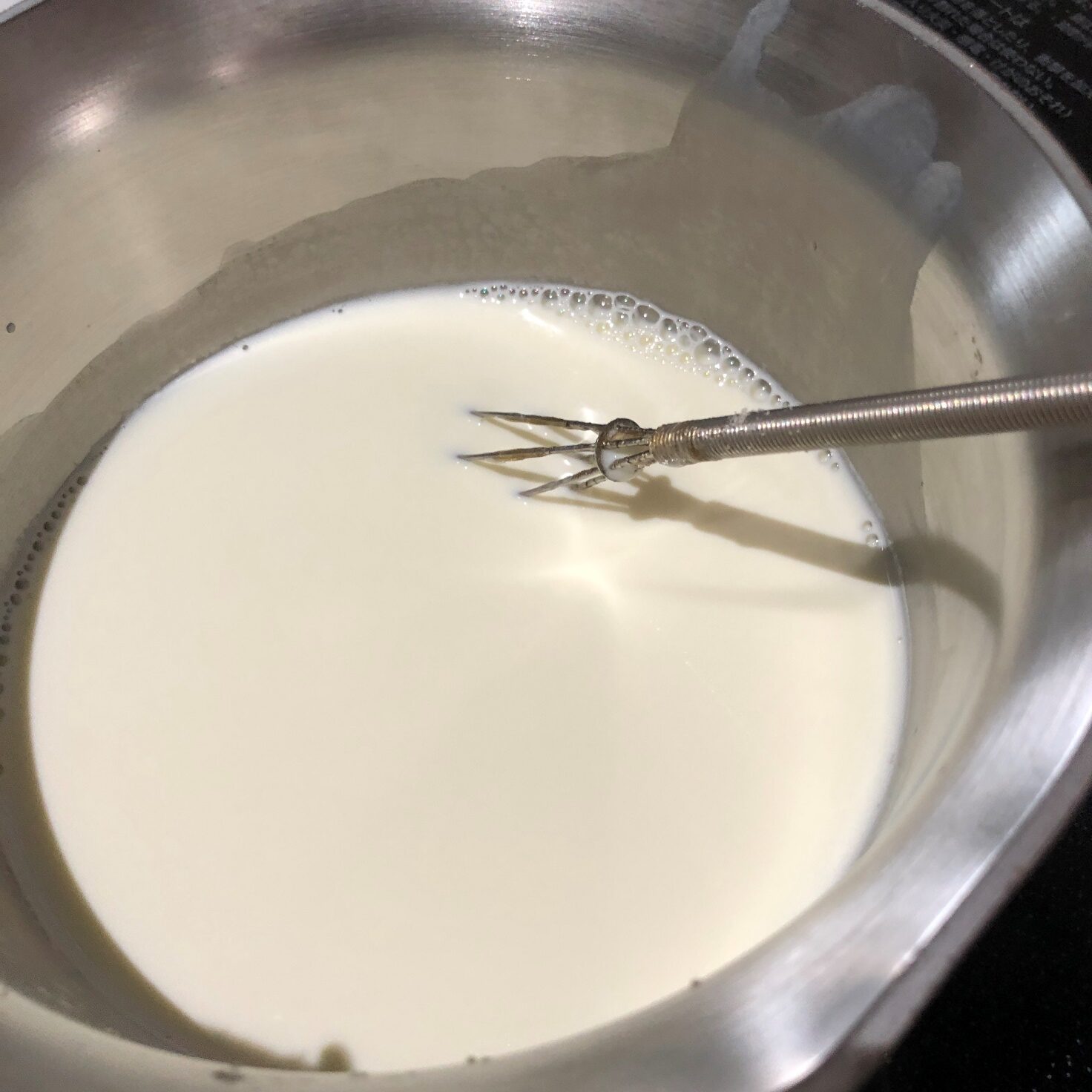 牛乳・生クリーム・砂糖・ふやかしたゼラチンを入れた鍋を火にかけながら、かき混ぜる