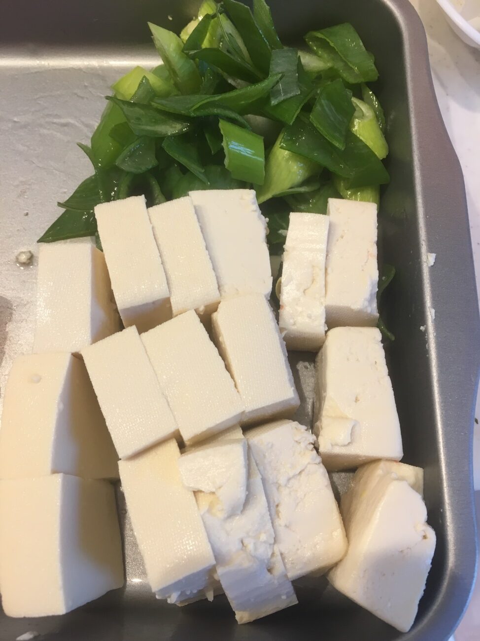 ねぎを薄切り、木綿豆腐を2cm幅に切る