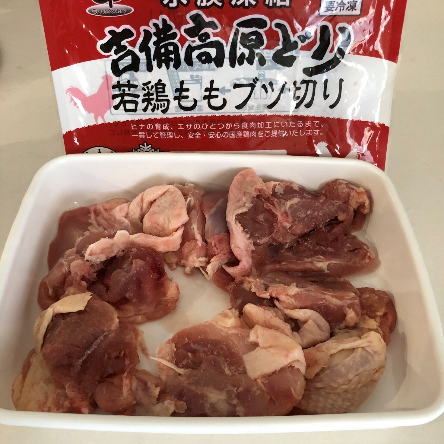 業務スーパーの吉備高原どり鶏ももブツ切りのパッケージと解凍した肉