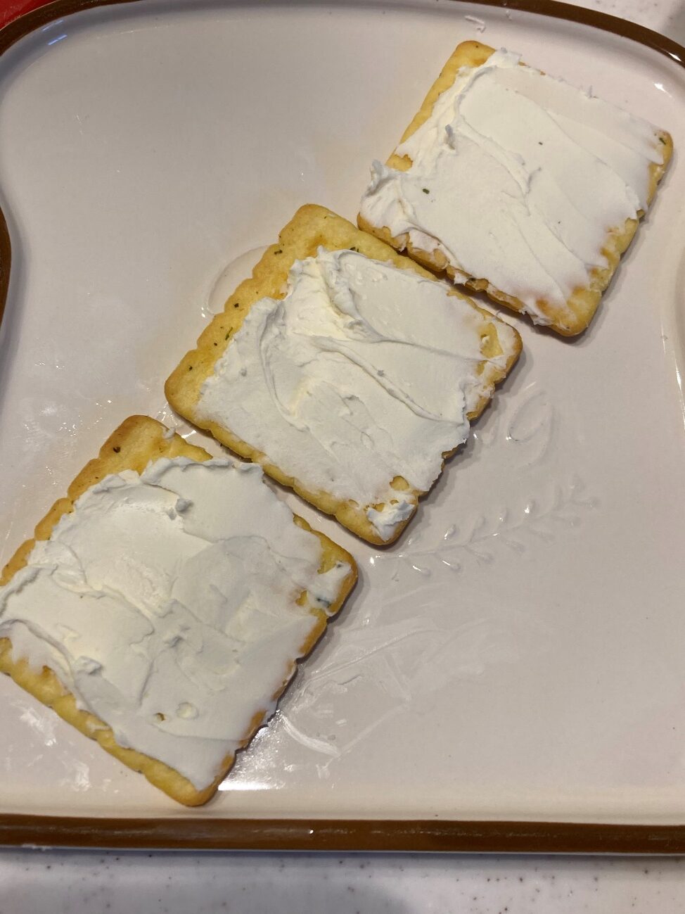 クラッカーに常温に戻したクリームチーズを塗る