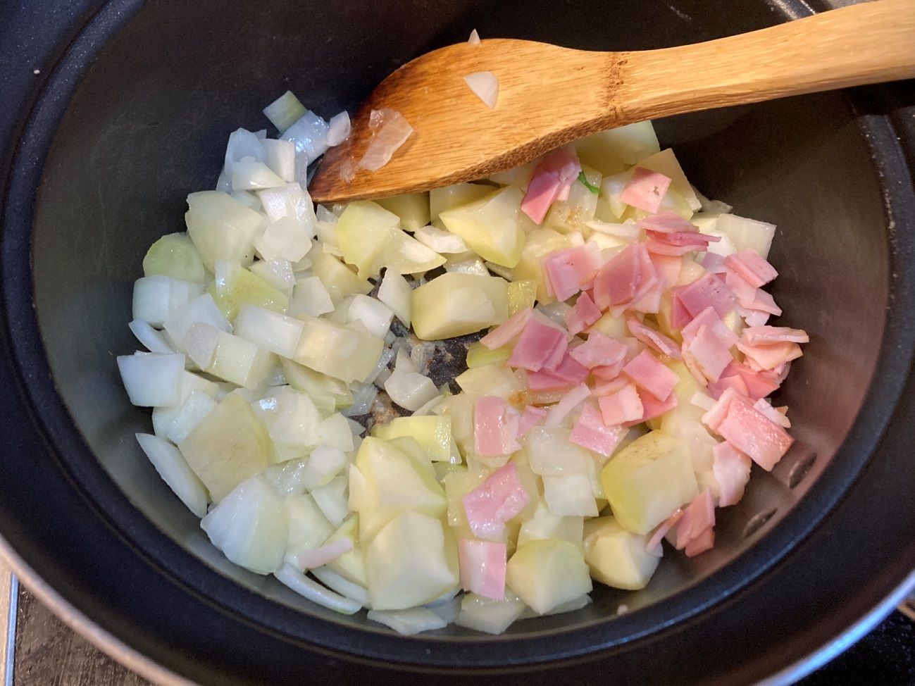 オリーブオイルを熱した鍋でじゃがいも・玉ねぎ・ハーフベーコンを炒める