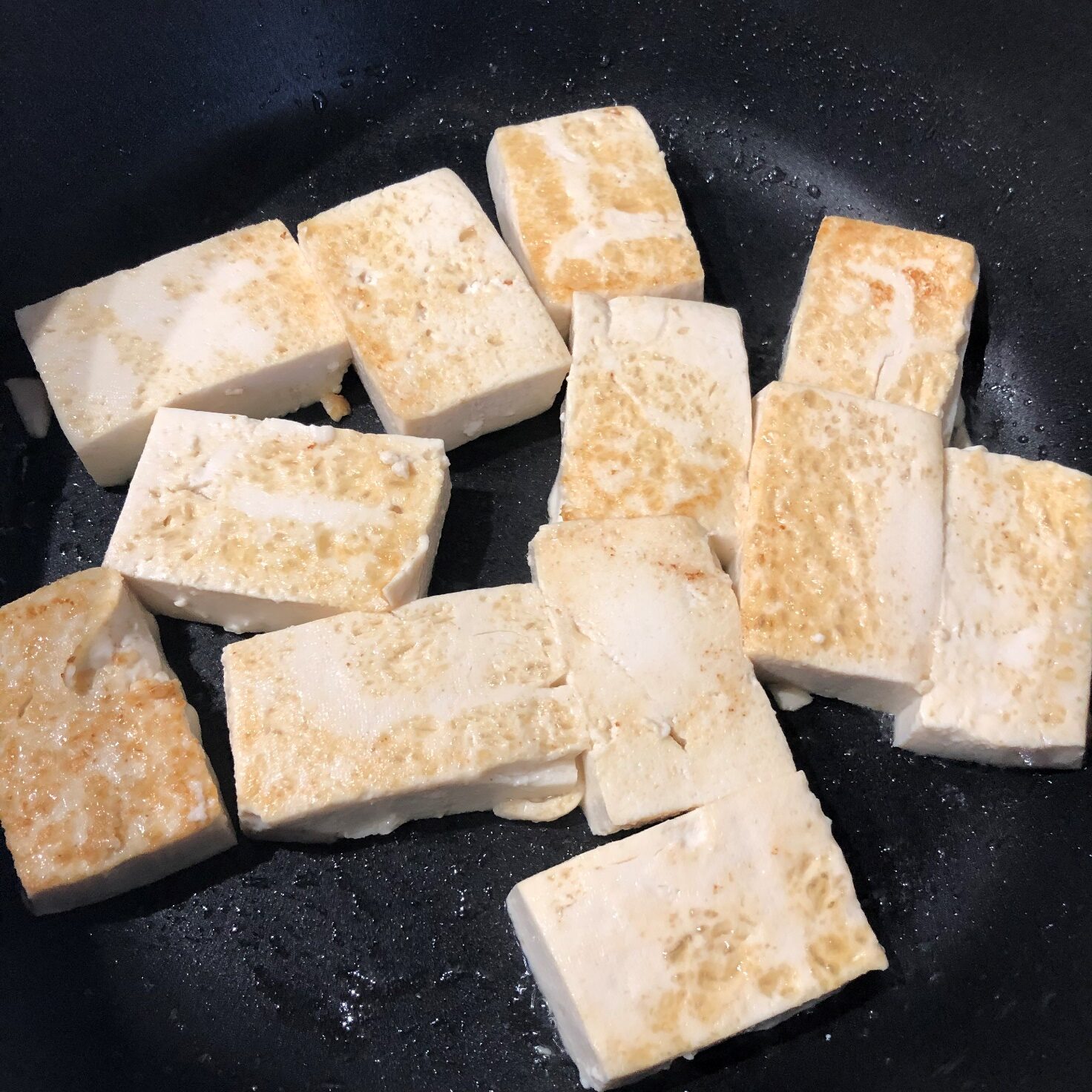 水切りして食べやすく切った豆腐をフライパンで焼く