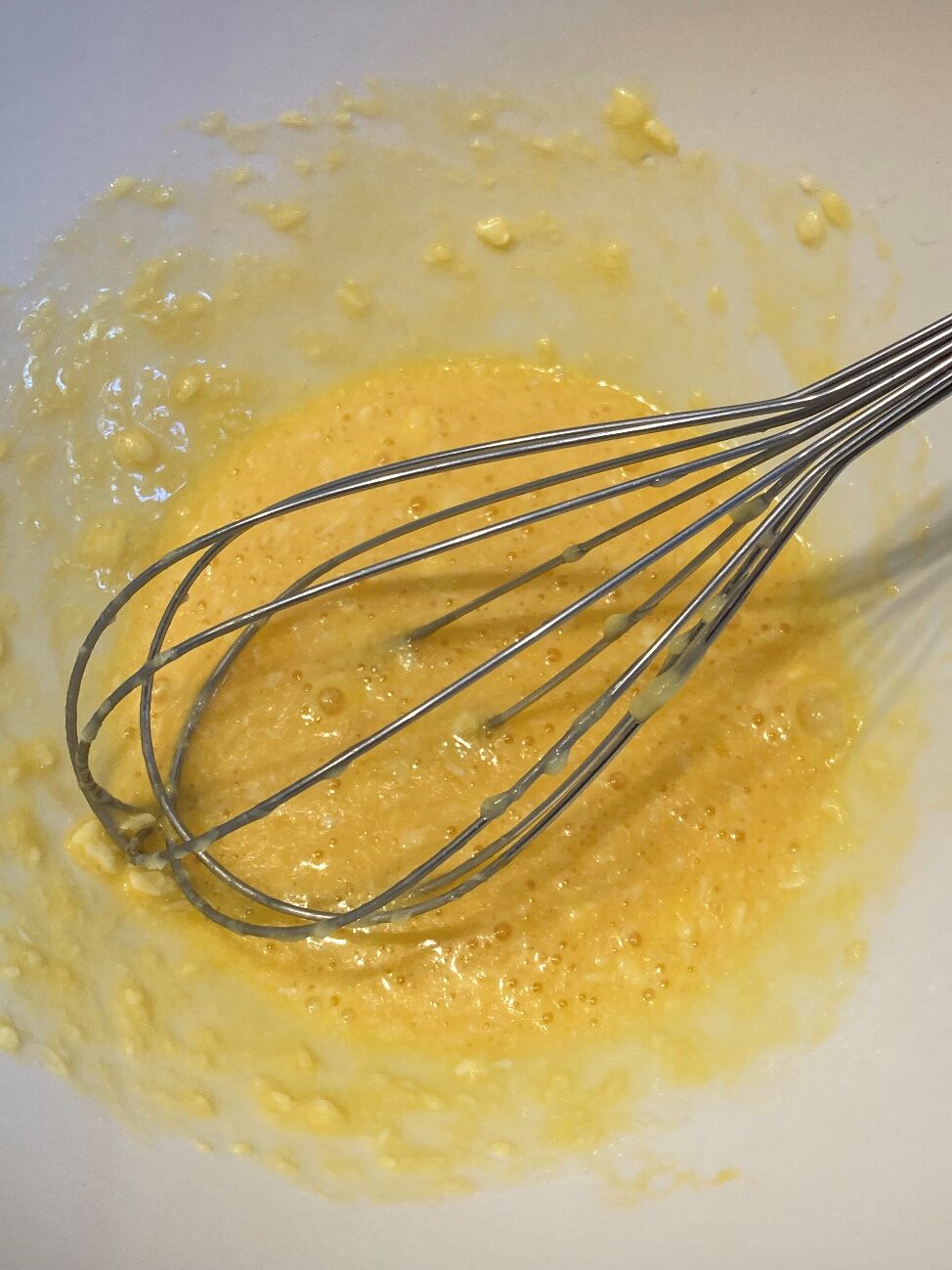 レンジ加熱した溶かしバターに卵を入れて混ぜる