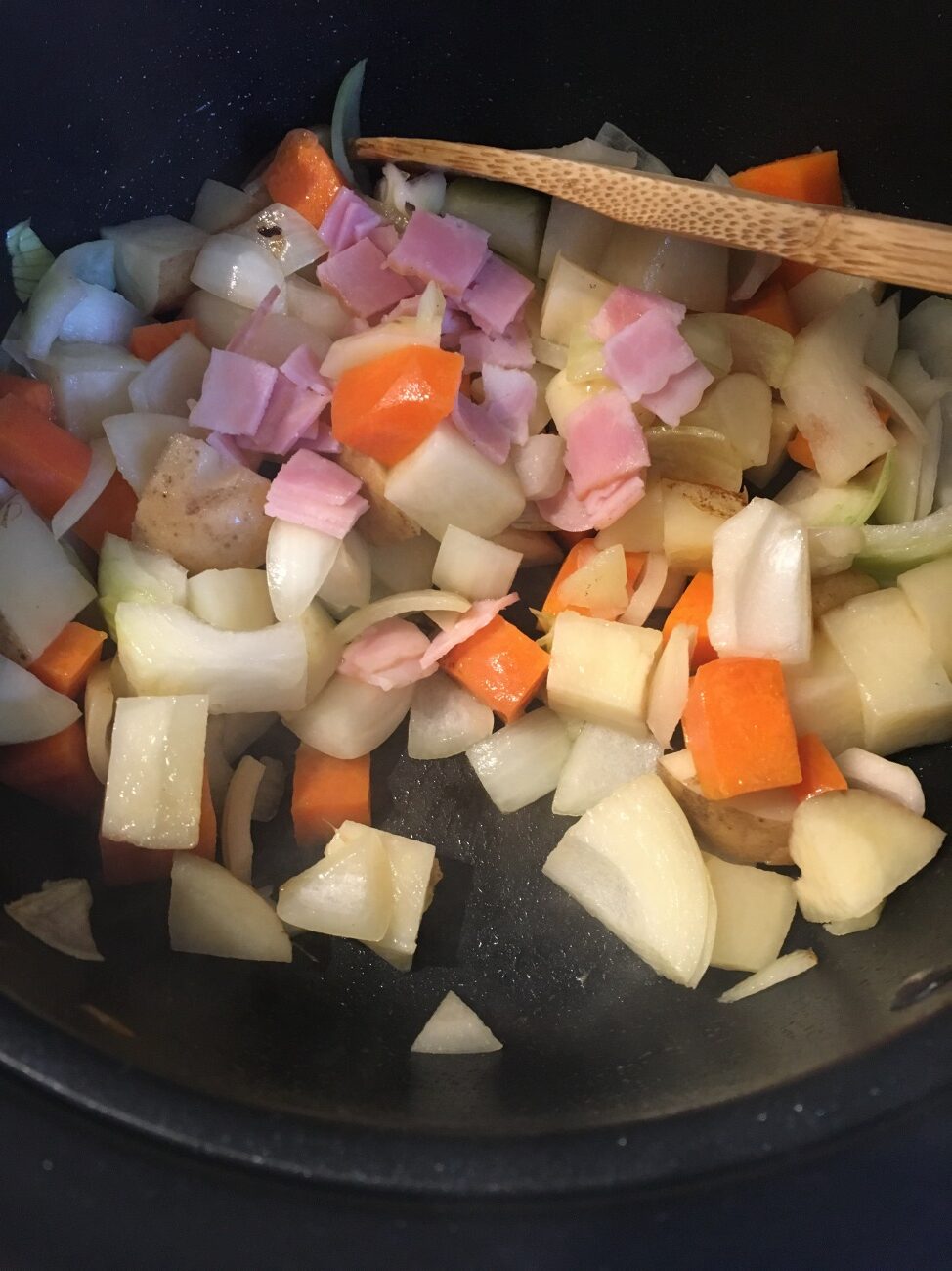 オリーブオイルを熱した鍋で野菜類とベーコンを炒める