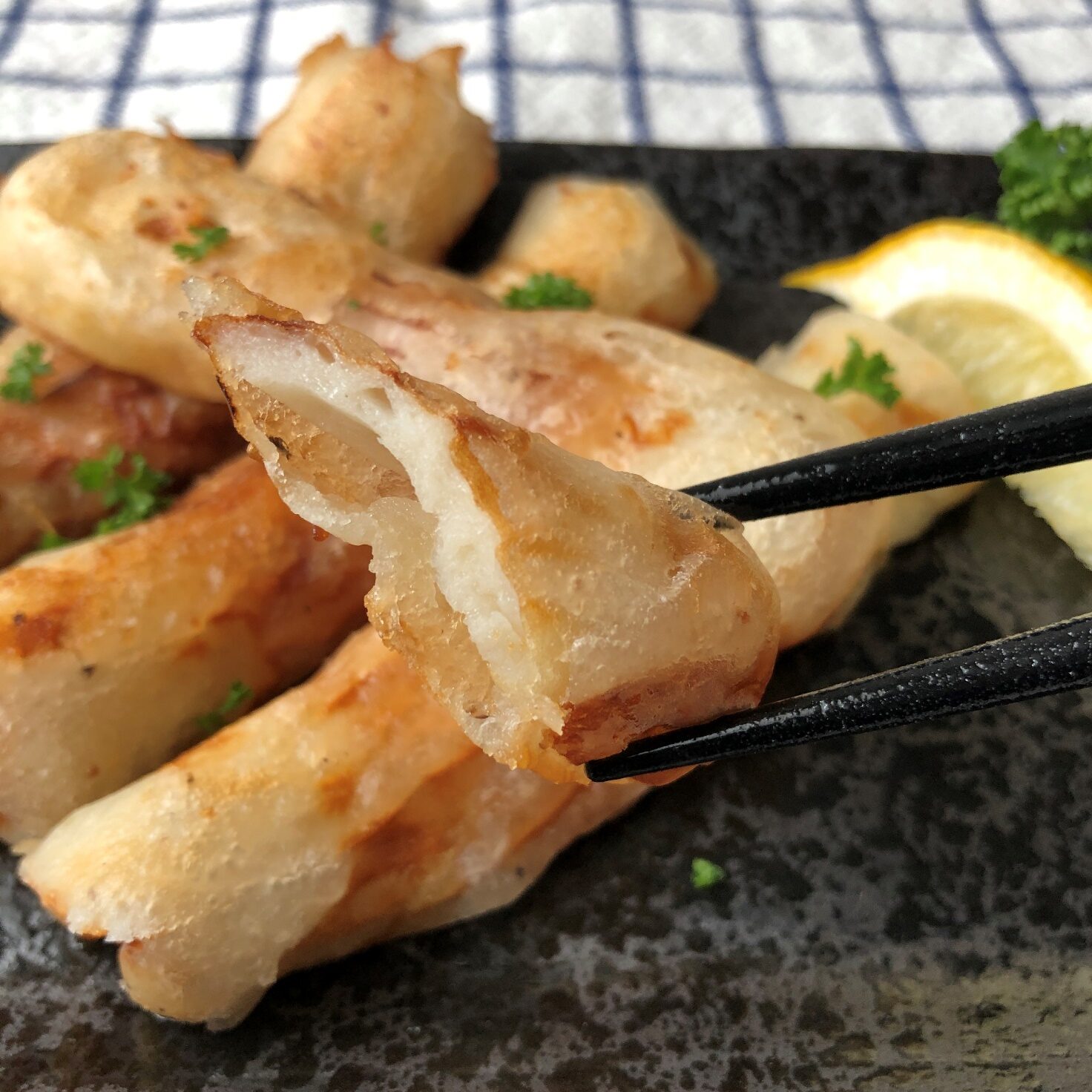 箸で持ち上げた業務スーパーのシーザーサラダドレッシングで作ったチーズ風味ちくわの天ぷらのアップ