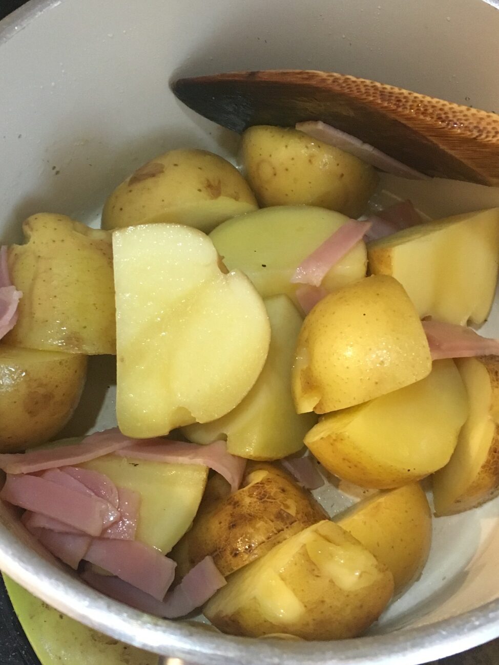 オリーブオイルを熱した鍋でじゃがいもとベーコンを炒める