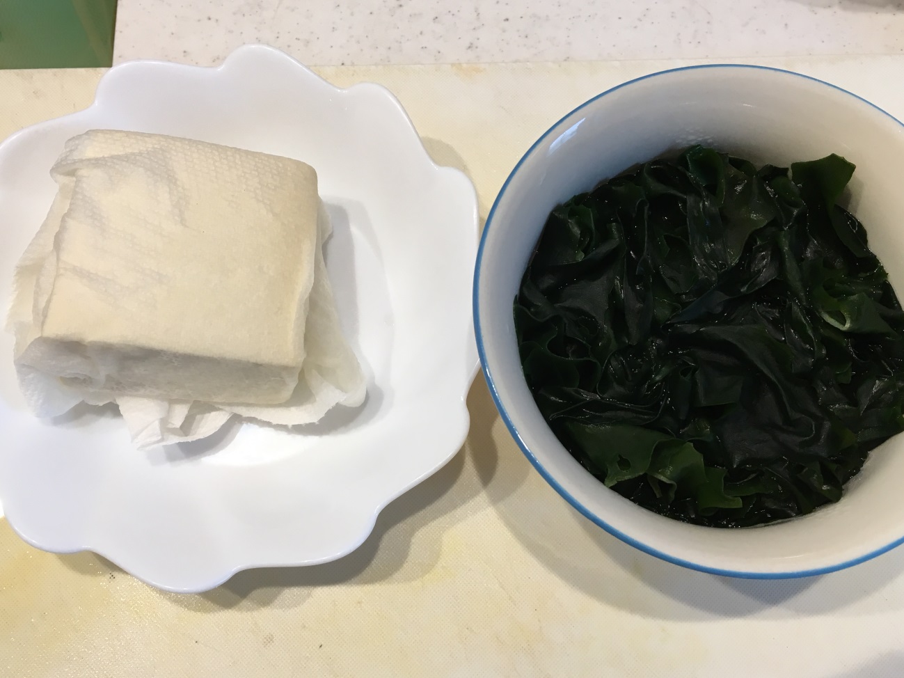豆腐をキッチンペーパーに包んで水切りし、乾燥わかめを水で戻しておく