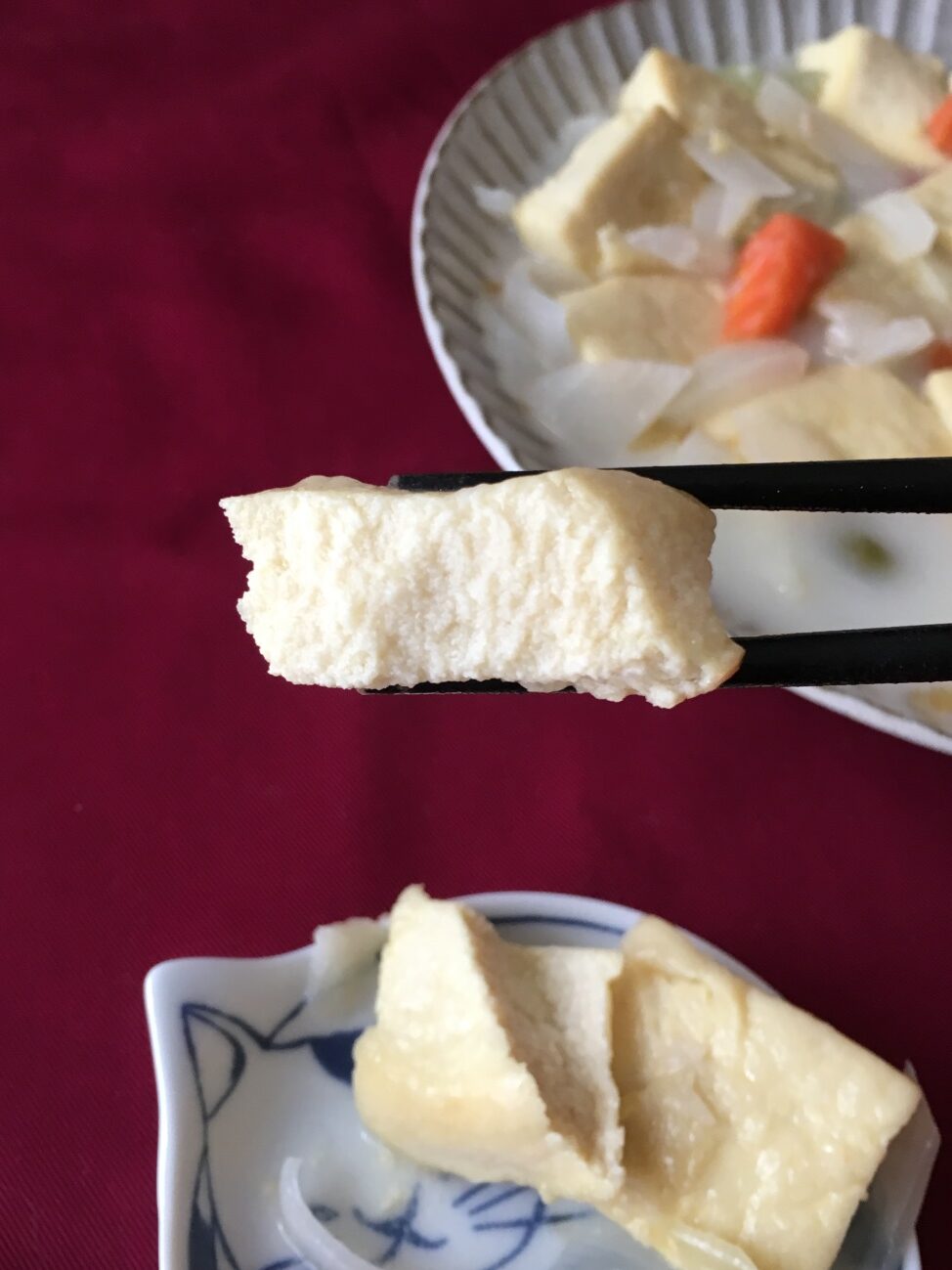 箸で持ち上げた業務スーパーのイタリアンミックスピクルスで作った南蛮漬けに入れた高野豆腐のアップ