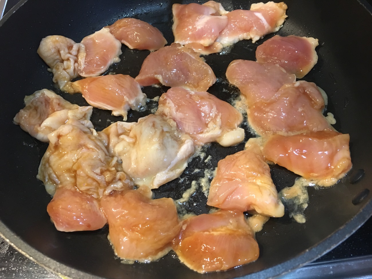 調味料に漬け込んだ鶏胸肉をフライパンで焼く