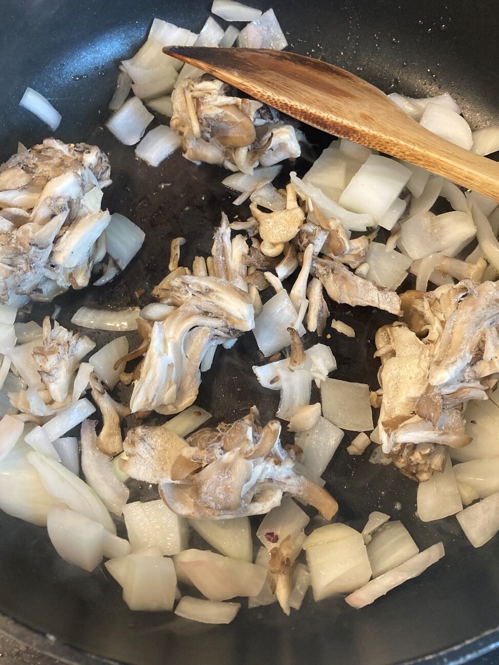 ごま油とチューブにんにくを熱したフライパンで、玉ねぎと舞茸を炒める