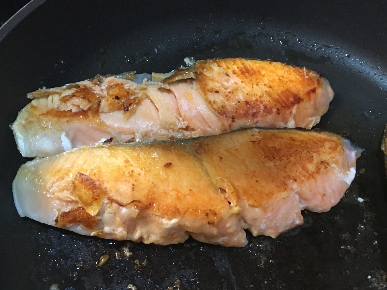 油を熱したフライパンで鮭を両面焼く