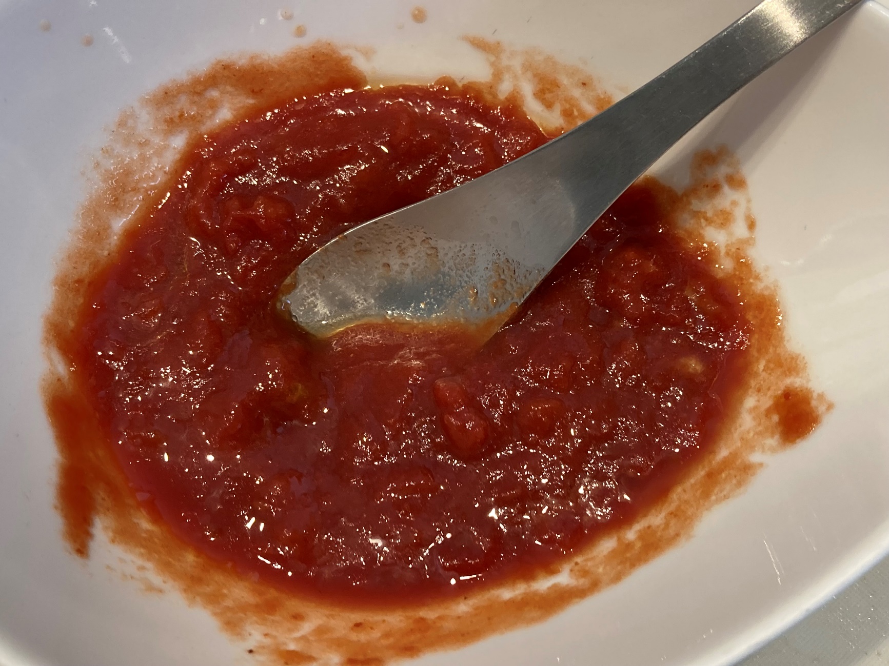 トマトソースの材料（カットトマト・お酒・はちみつ・コンソメ）を混ぜ合わせる