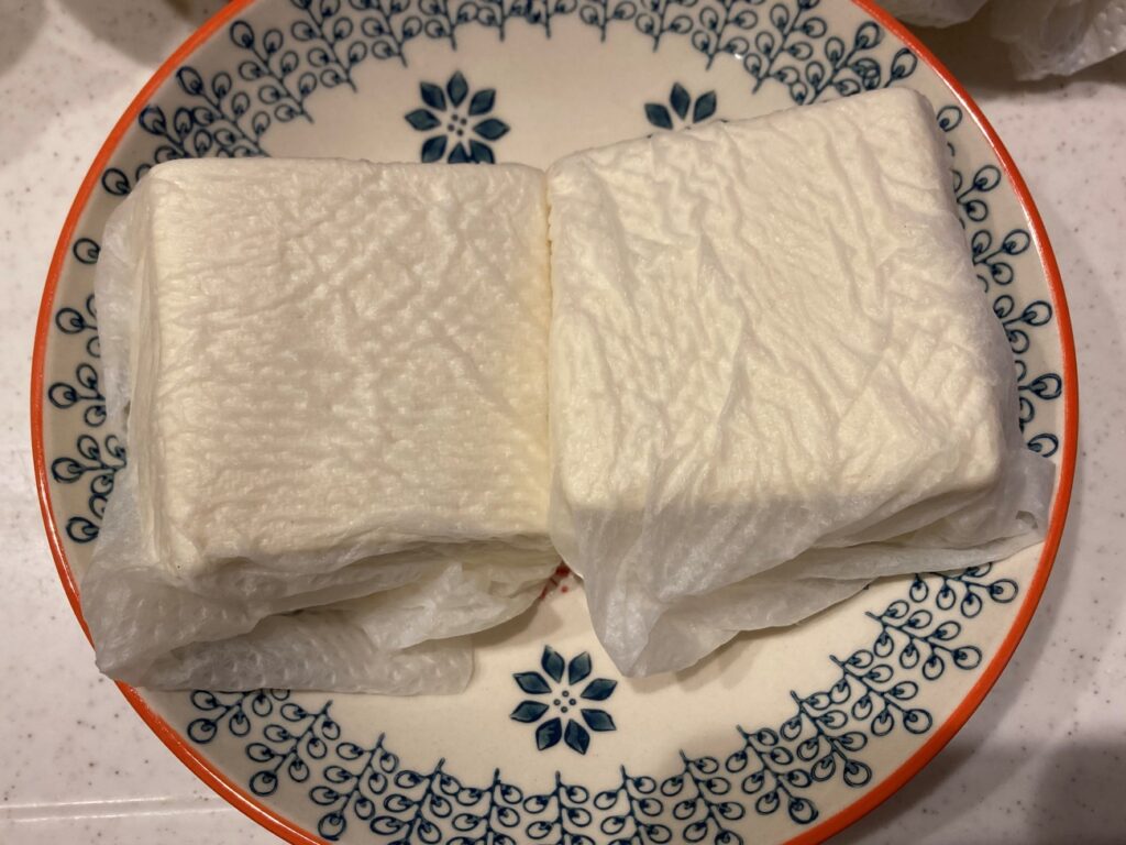 木綿豆腐を水切りするために、キッチンペーパーで包む