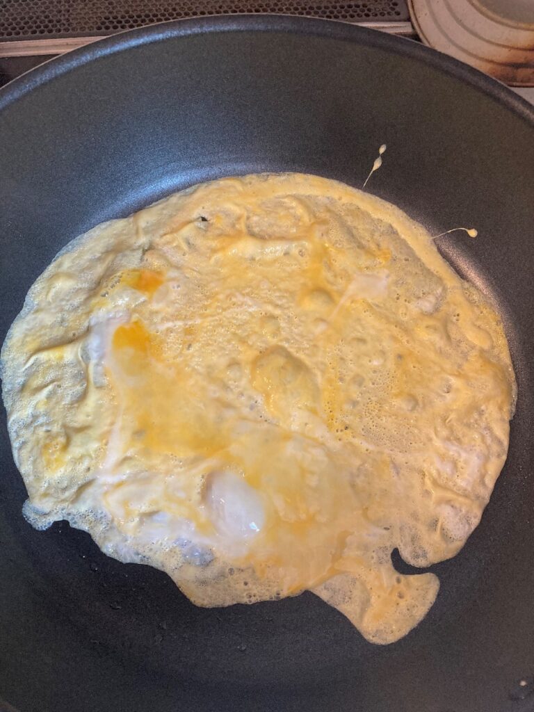 バターを熱したフライパンに溶き卵を入れて焼く
