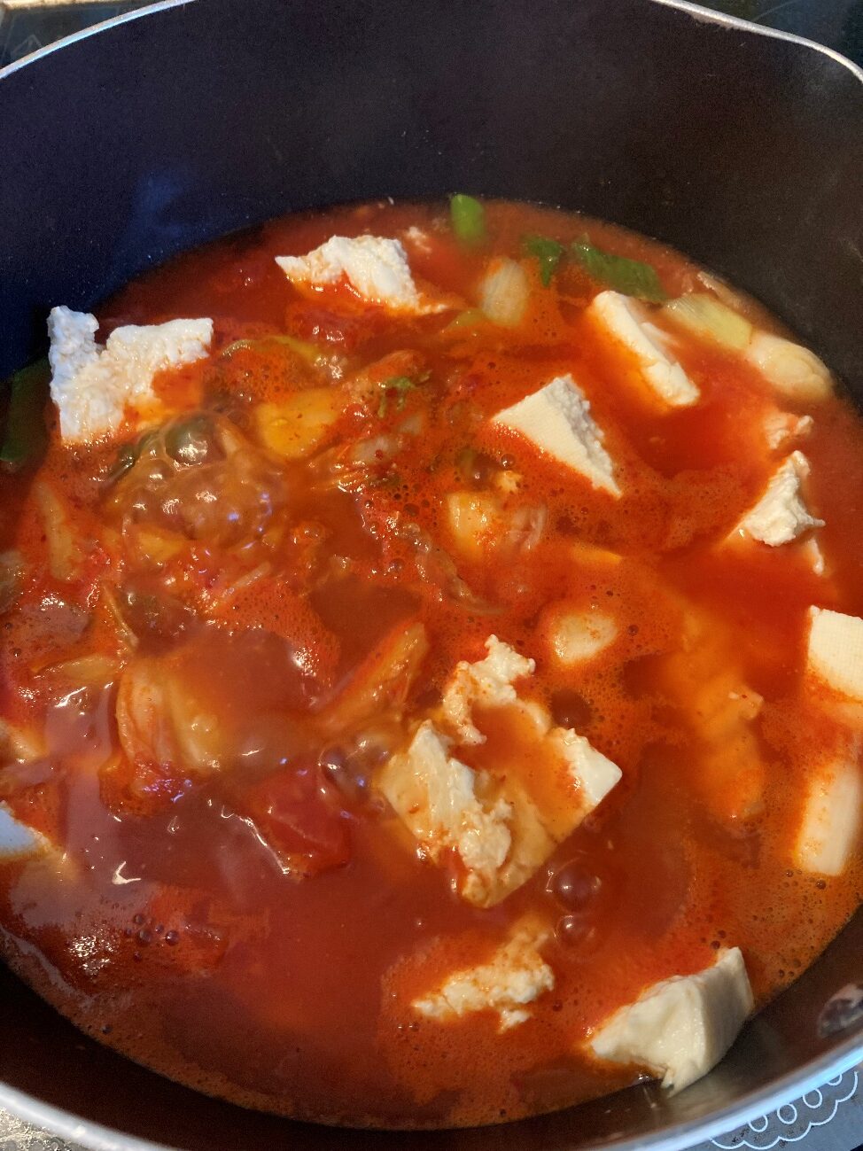 水とオーガニックカットトマト缶詰を入れたところに豆腐・キムチ・鶏がらスープの素・オイスターソースを加える