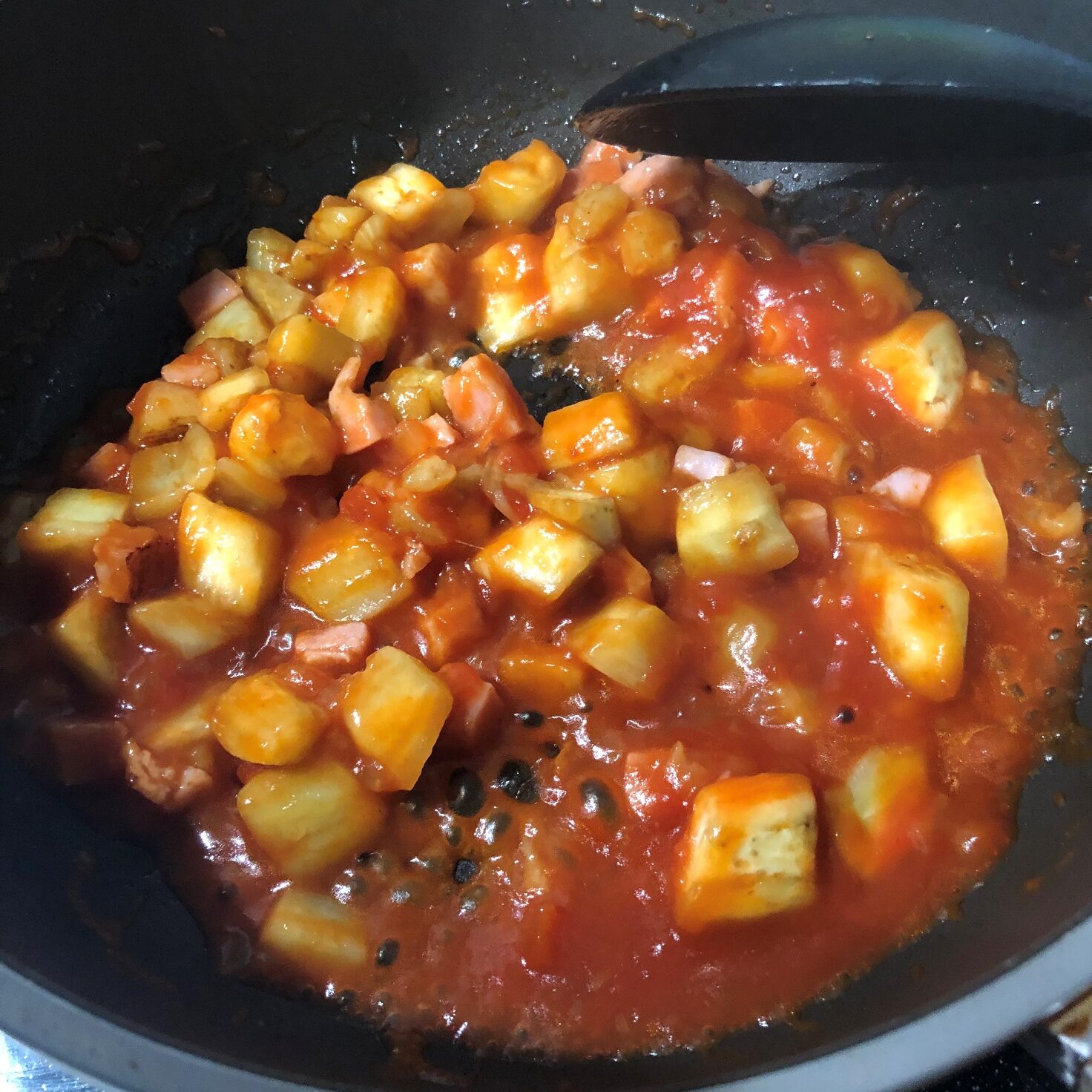 炒めた米茄子とベーコンに業務スーパーの完熟トマトソースを加える