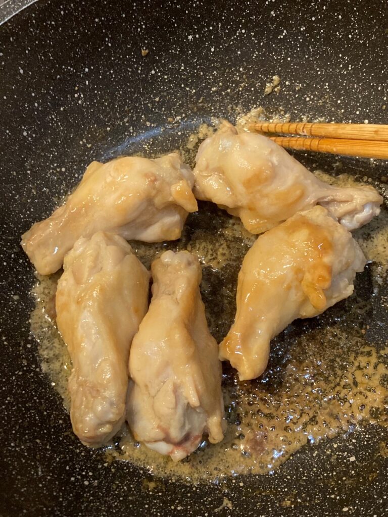 業務スーパーの鶏白湯しょうゆ鍋つゆに漬けた鶏手羽元をごま油を熱したフライパンで焼く