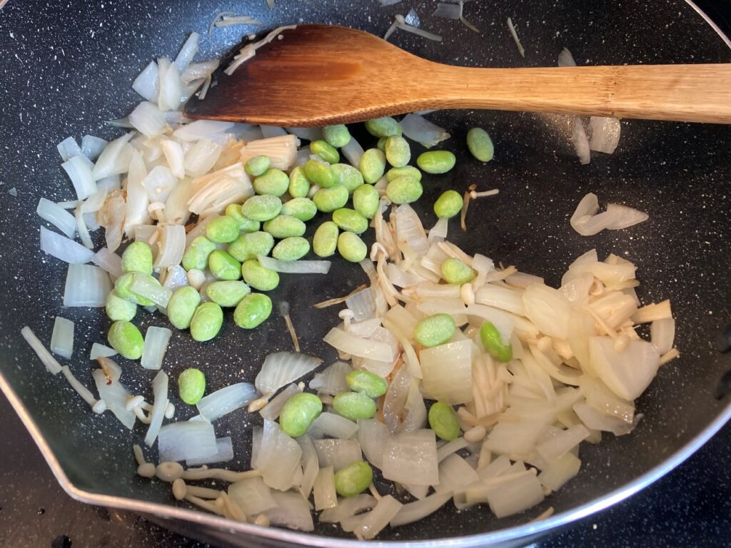 オリーブオイルを熱したフライパンで玉ねぎ・えのき・むき枝豆を炒める