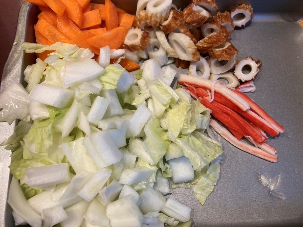 人参を短冊切り、ちくわを斜め薄切り、白菜を2cm幅に切り、かにかまを裂いておく