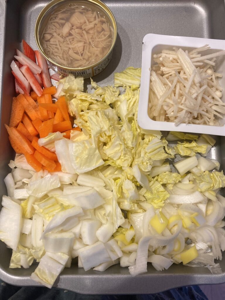 人参を短冊切り、白菜を2cm幅にし、かにかまをほぐし、えのきと帆立の缶詰も用意しておく