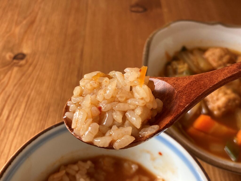 スプーンですくった業務スーパーのキムチ鍋の素を使ったキムチ鍋の残りスープで作った雑炊のアップ